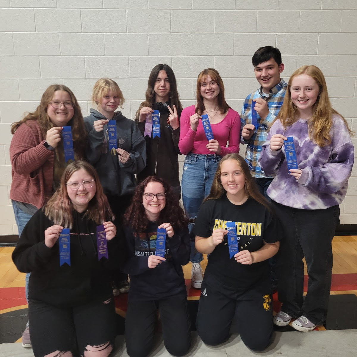 The 2023 Spell Bowl team is pictured with their first-place ribbons from regionals! From left to right: (Back row: Giszelle Pfeiffer, Ava Madigan, Jackson Bender, Marlee Wilson, Logan Arthur, Bailey Pikula). Front row: (Carson Foster, Rebecca Adcock, Jocelyn Ringler). 
