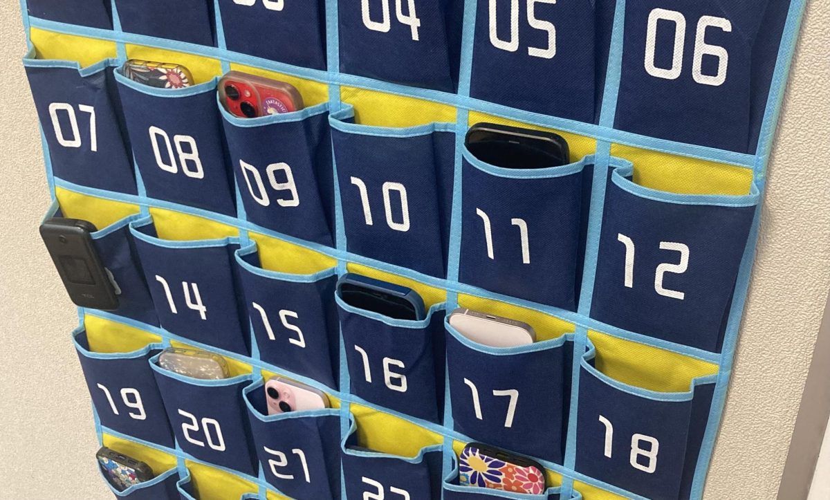 Students keep their phones in pouches on the wall during classtime. 