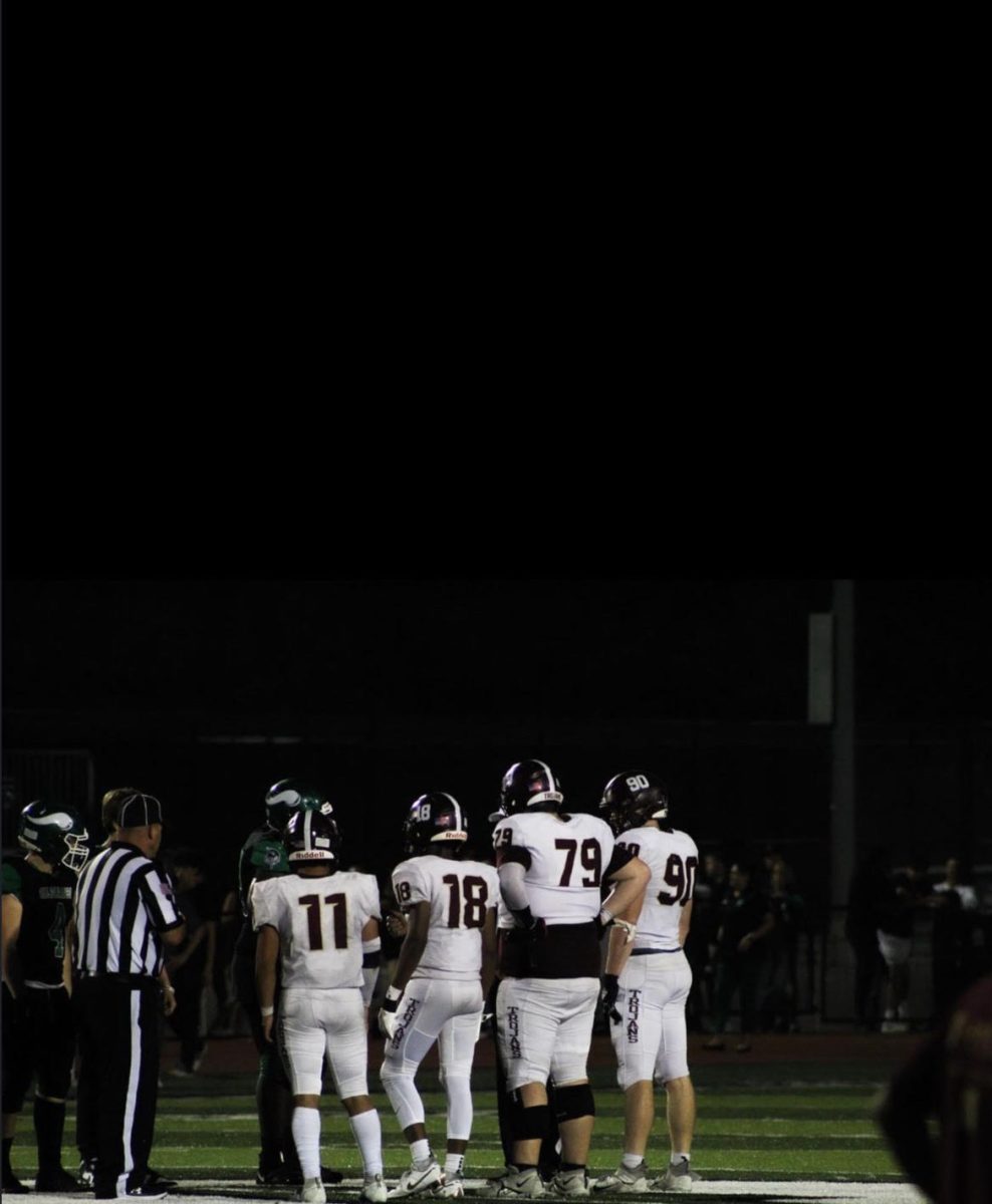 The captains from each team meet for the coin toss.