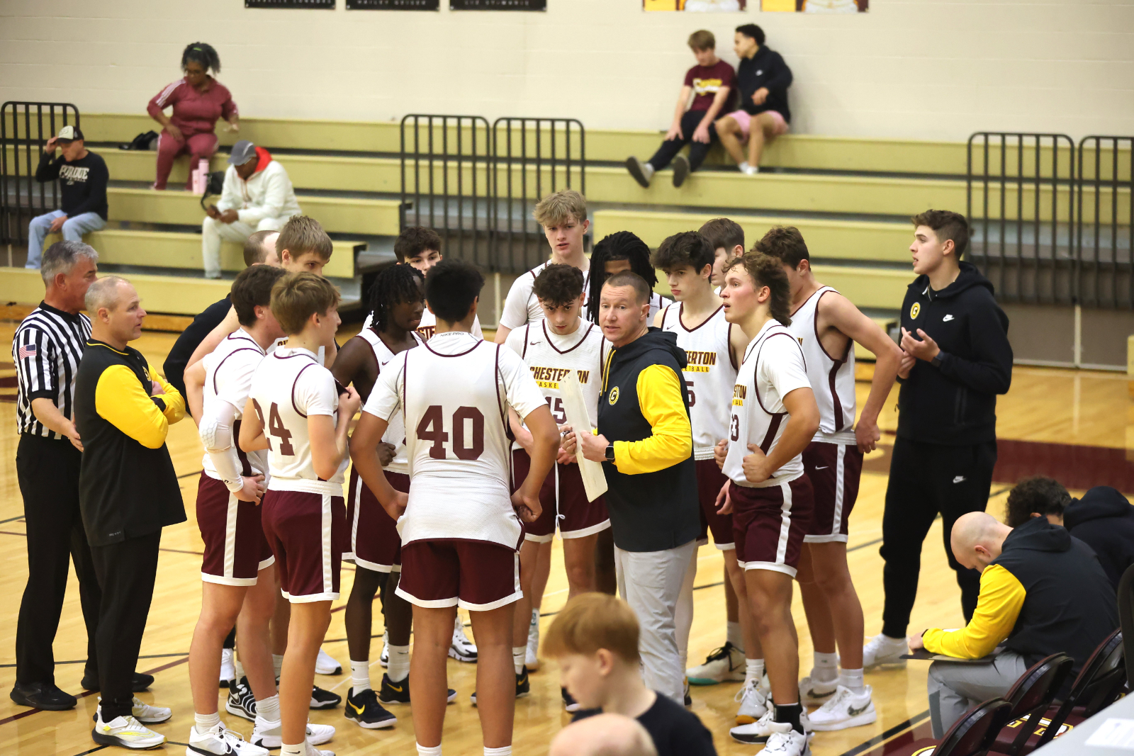 Boys Basketball Coach Urban meets with his team during a timeout in a scrimmage